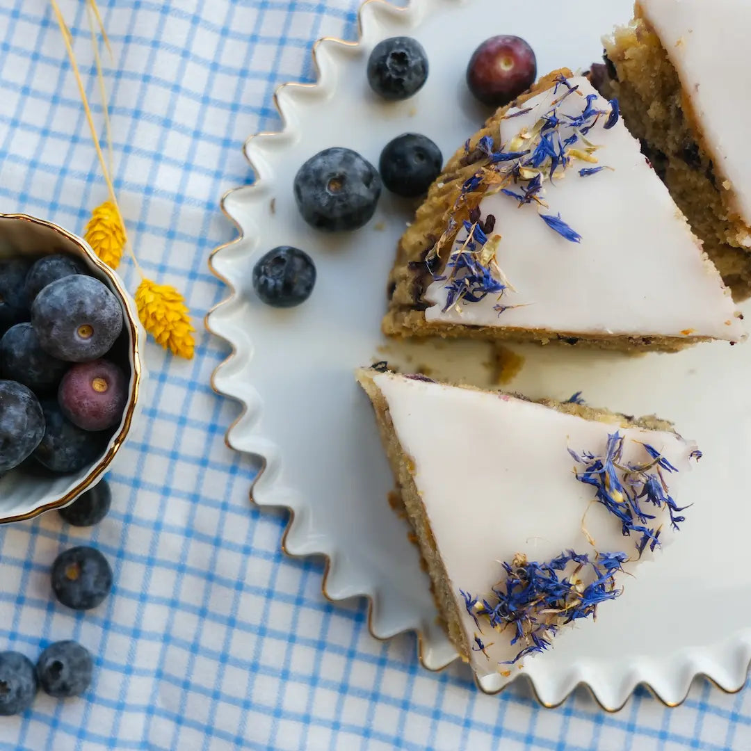 Blaubeerkuchen von Kuchentratsch von oben auf karierter Tischdecke