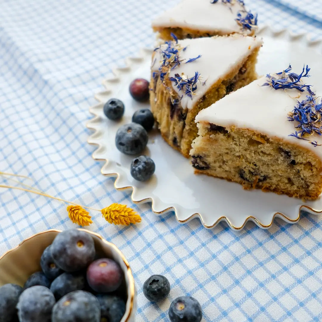 Drei Stücke Blaubeerkuchen von Kuchentratsch auf karierter Tischdecke