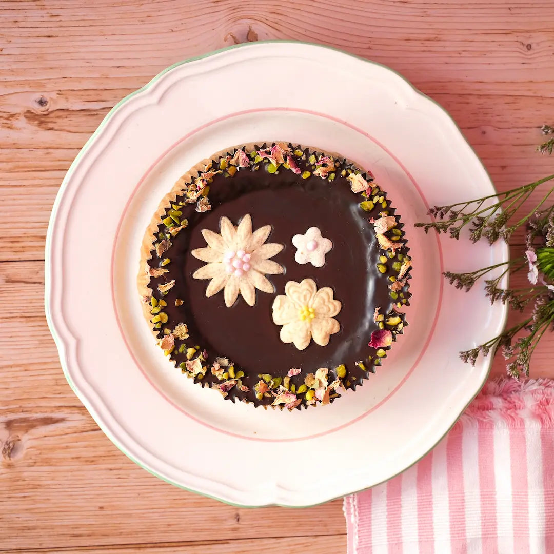 Der Frühlingskuchen von den Omas von Kuchentratsch mit Mürbteig Blumen verziert.