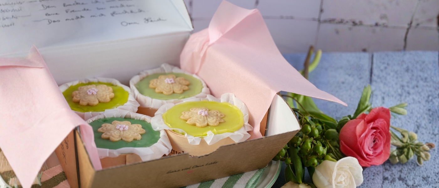 Die Frühlingstörtchen von Kuchentratsch auf blauem Tisch mit Blumen