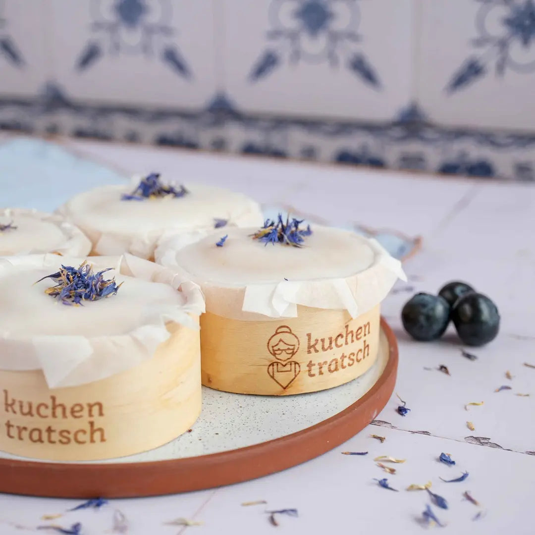 Heidelbeer Muffins von Oma Hildegard auf weißen Fließen mit Tischdecke und Blütendeko