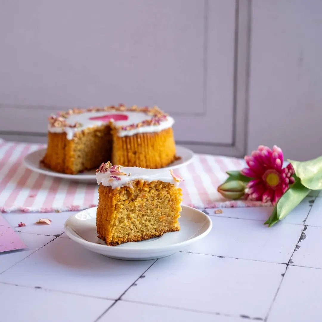 Unser Herzkuchen Karotte mit Herzwunderkerze angeschnitten auf Tischdecke von Kuchentratsch