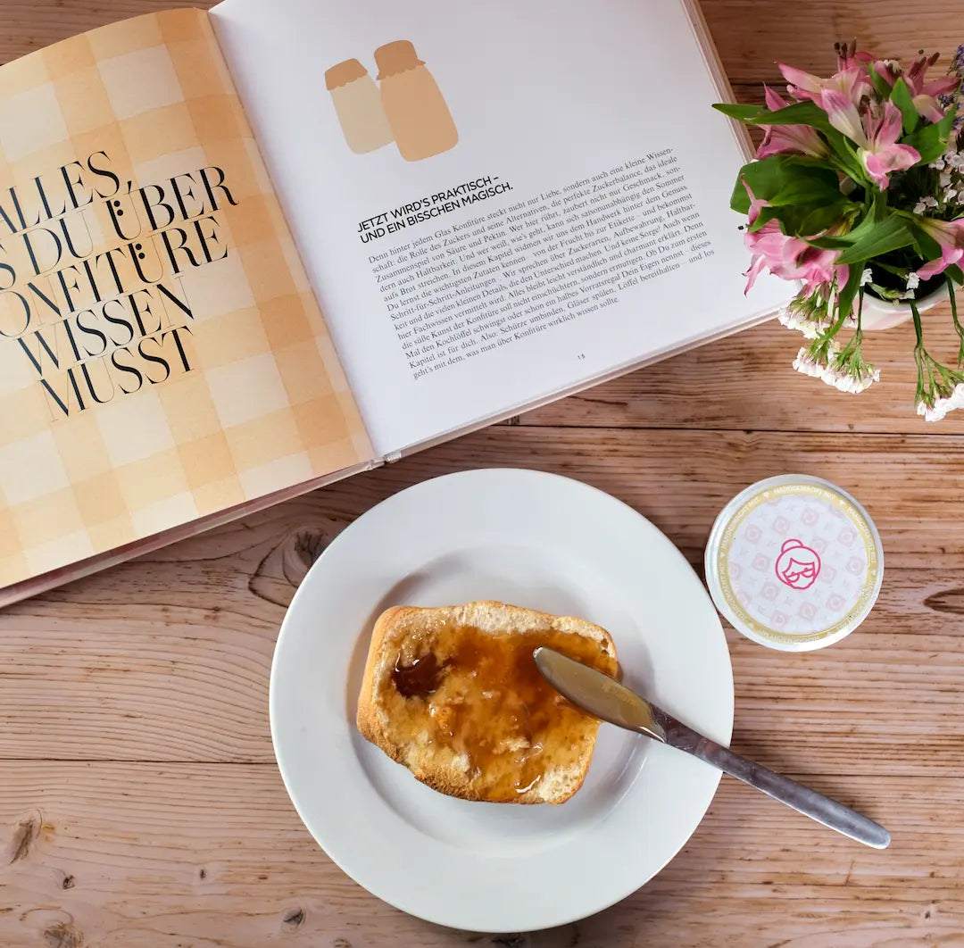 Vier Gläser fruchtiges Quittengelee und das Buch „Die Marmeladenköniginnen“ liebevoll zusammengestellt als Geschenkset