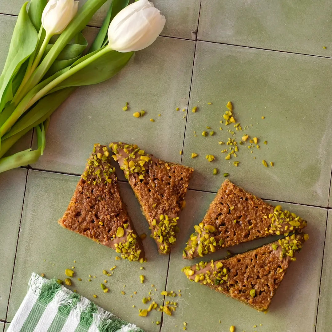 Die Pistazienecken von den Kuchentratsch Omas auf grünen Fließen mit weißen Tulpen und Pistazien.