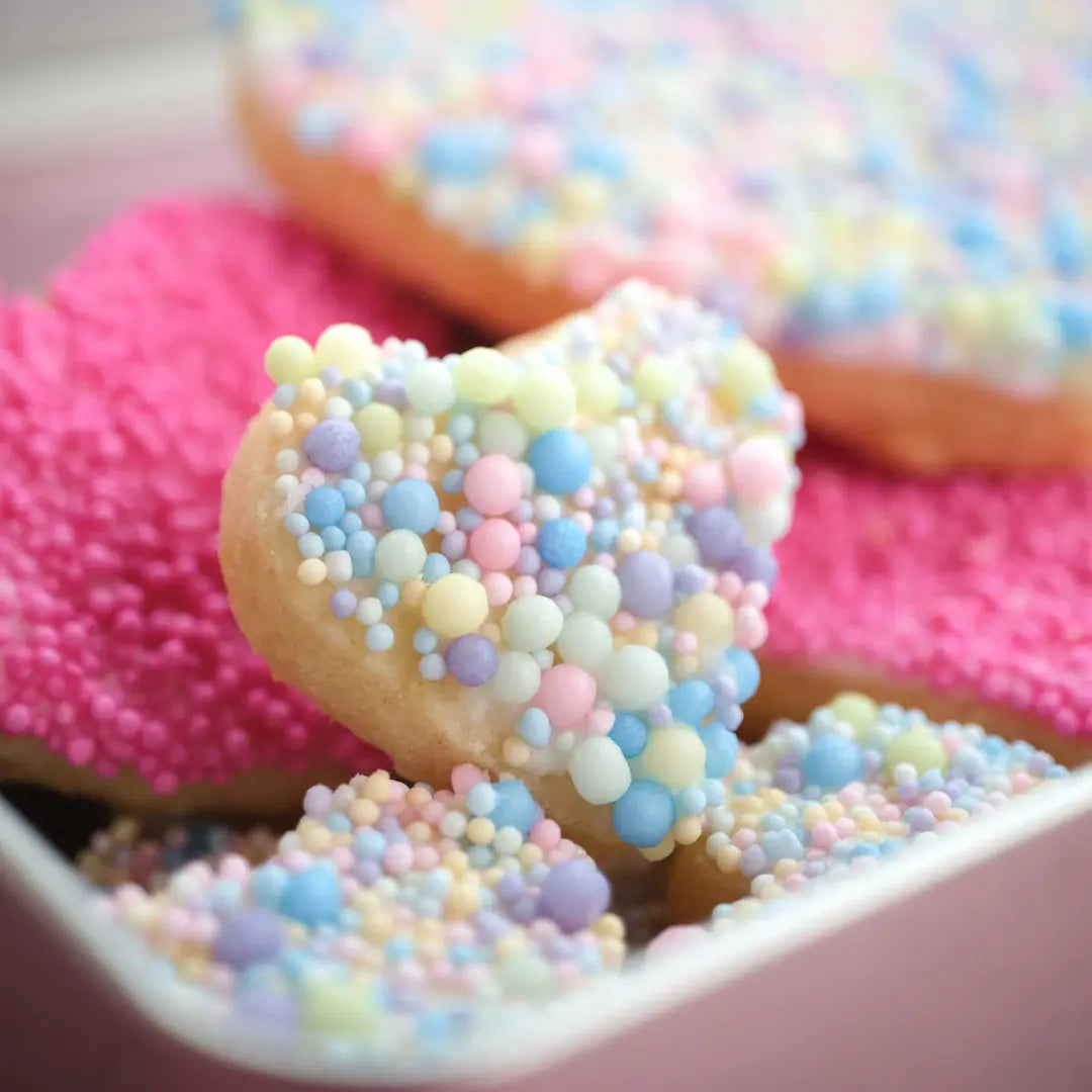 Nahaufnahme der Kuchentratsch Herz Kekse, liebevoll veredelt mit pastellfarbenen Streuseln