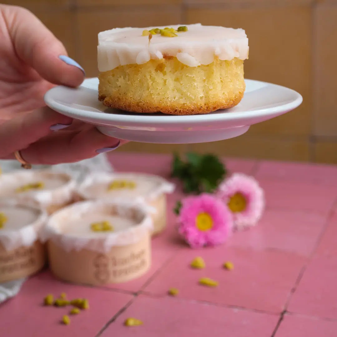 Ein Zitronen Muffin von Kuchentratsch auf kleinem Teller in der Hand einer Person
