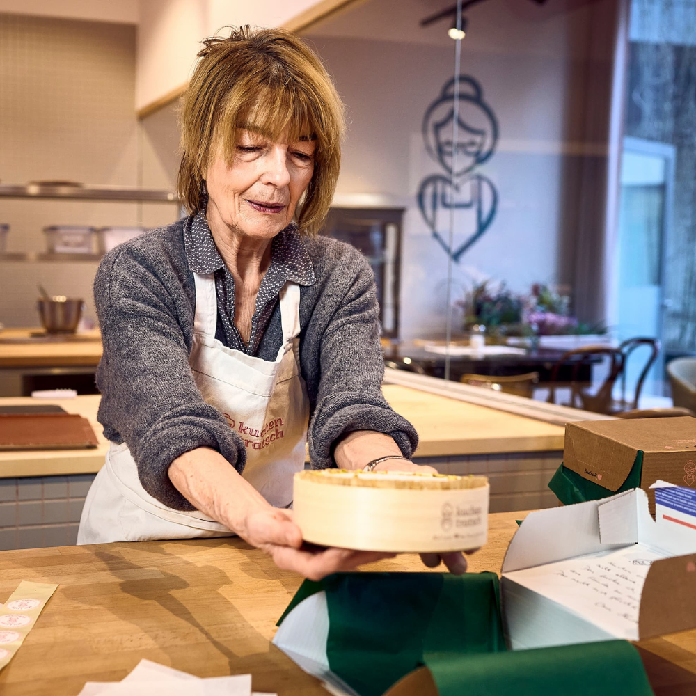 Verschicken der Kuchen. Eine unserer Rentnerinnen beim Packen unserer Versand-Kuchen von Kuchentratsch