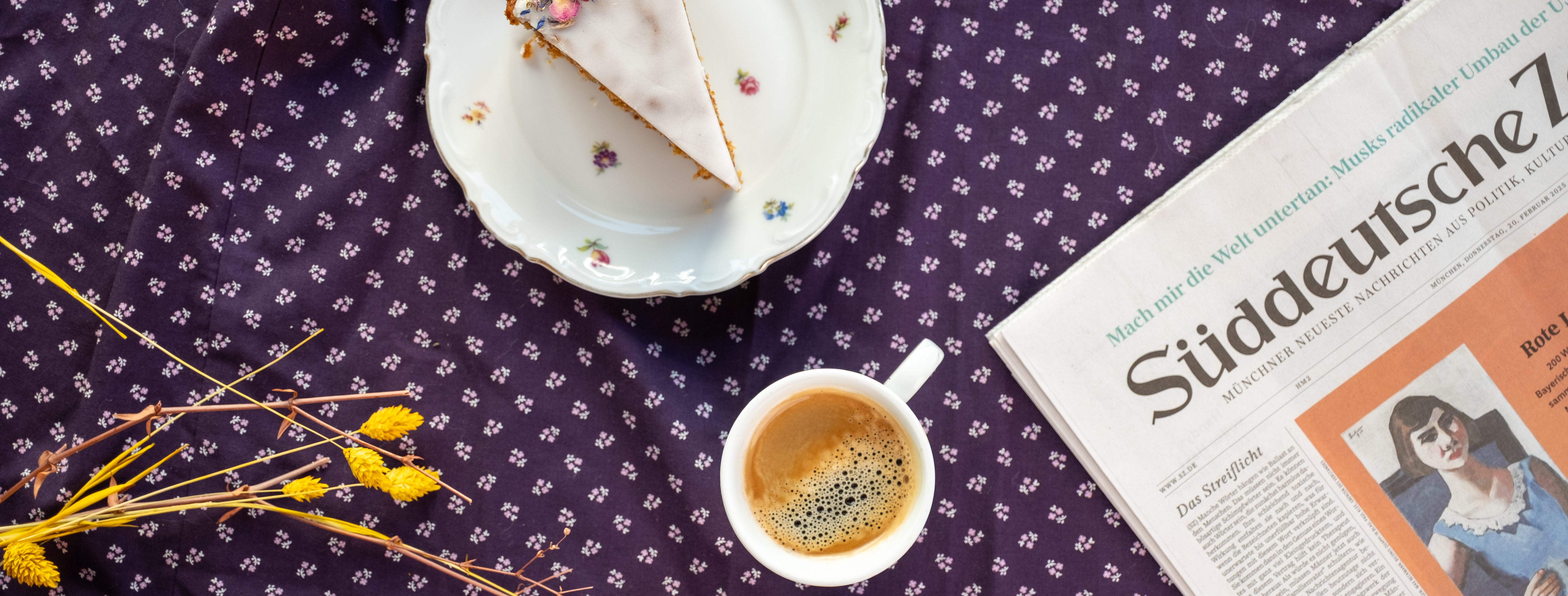 Ein Stück Torte, eine Zeitung und eine Tasse Kaffee auf einem Tisch