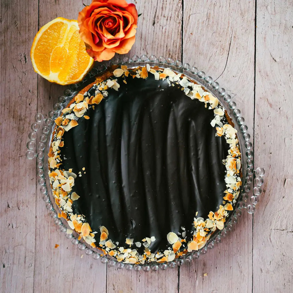 Orangen Mandel Tarte von Kuchentratsch auf Holztisch mit einer Rose