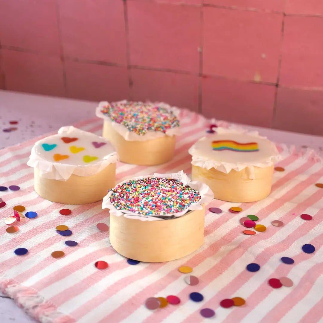Das Kuchentratsch Muffin Set im Happy Pride Look seitlich mit Konfetti auf einem Tisch