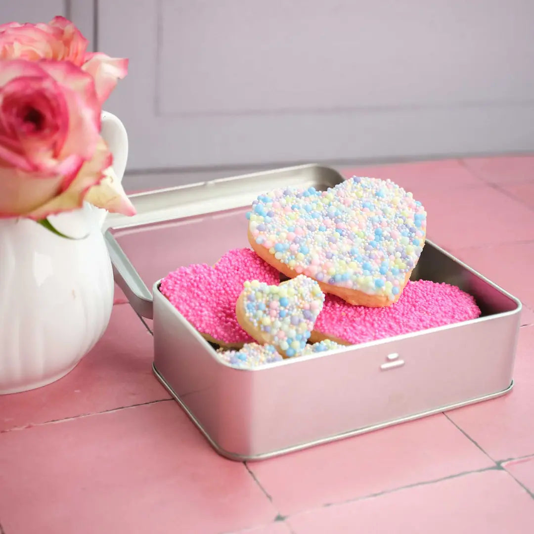  Zart-mürbes Gebäck in Herzform, liebevoll veredelt passend zum Valentinstag in Pastellfarben in Versanddose