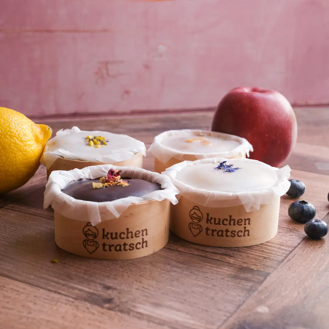 Vegane Muffins von Kuchentratsch in vier verschiedenen Sorten mit Früchten auf einem Tisch 